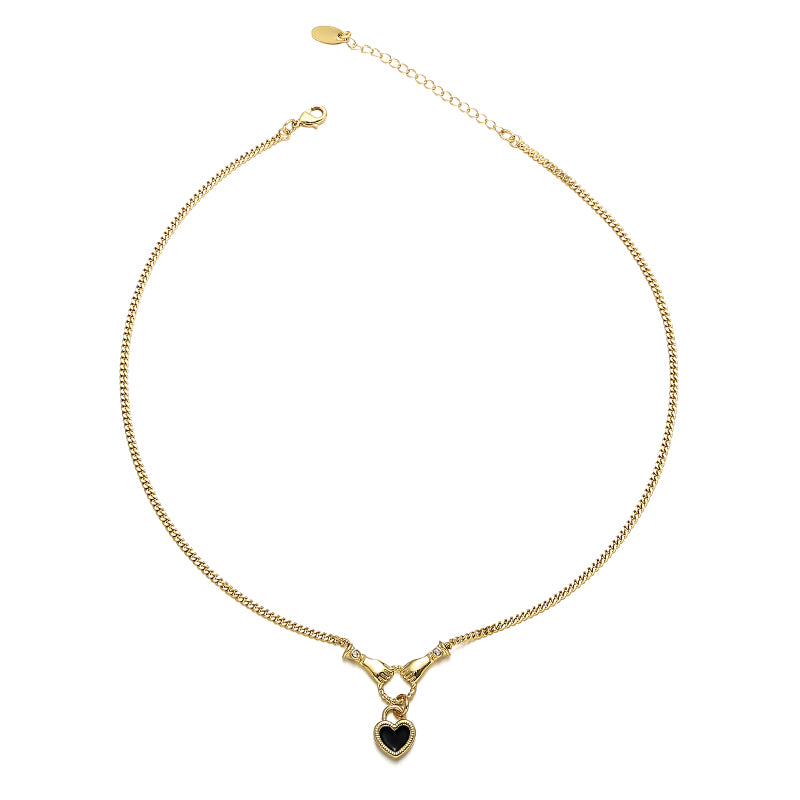 This image showcases a romantic heart enamel pendant necklace with a unique hand gesture design, featuring a sparkling zircon inlay. The vibrant red enamel heart adds a touch of vintage elegance, making it a perfect accessory for date nights, casual outfits, or special occasions. The pendant is suspended from a delicate gold or platinum chain, enhancing its luxurious appeal.