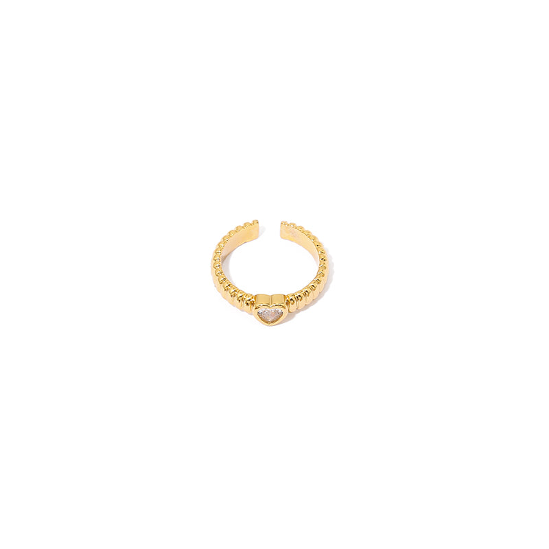 This image displays a hollow heart shaped zircon ring with a minimalist vintage design. The ring features black and white zircon stones and an 18K gold-plated brass structure. It's a perfect accessory for those who enjoy delicate and retro-chic jewelry styles. Ideal for casual and evening wear, it adds a modern touch to any outfit.