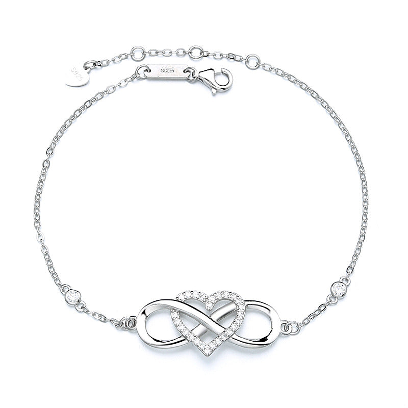 A woman wearing a polished 925 sterling silver bracelet with an infinity love symbol and intertwined heart-number 8 design, styled on the wrist for daily minimalist outfits or as a meaningful gift. The bracelet shines in a bright silver tone, blending symbolic elegance with modern simplicity.
