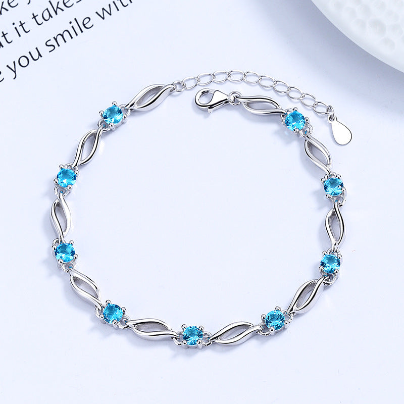 A model wearing a luxe blue crystal bracelet made of S925 sterling silver, featuring a minimalist Korean-inspired design. The bracelet shines in a polished silver tone with icy blue accents, styled for daily elegance or as a sophisticated gift for special occasions.