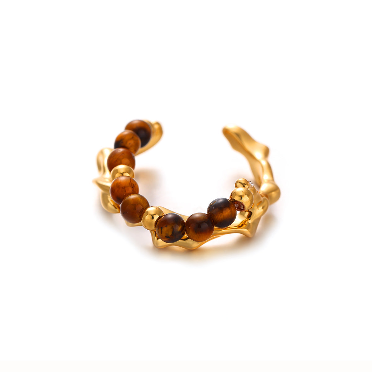 A model's hand wearing a luxe tiger eye stone ring with golden striations, paired with a cashmere sweater and leather gloves for autumn styling. The hypoallergenic brass band maintains its gold-plated finish against winter elements, while the stone's amber hues transition seamlessly from daytime meetings to evening events.