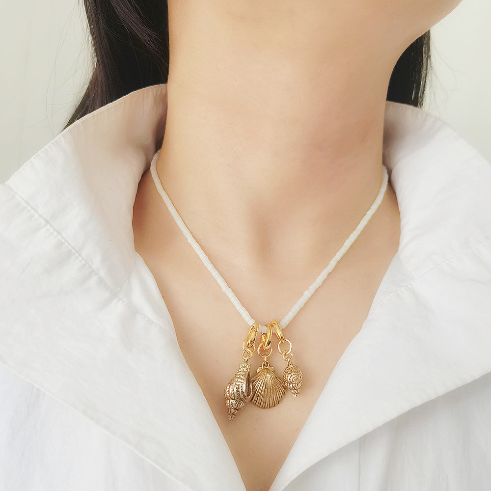 The image showcases a vintage-inspired pearl choker necklace with a gold-tone chain, featuring baroque-style details for a sophisticated and elegant look. This collarbone-length necklace is perfect for adding a touch of timeless charm to evening wear, special occasions, or everyday fashion statements.