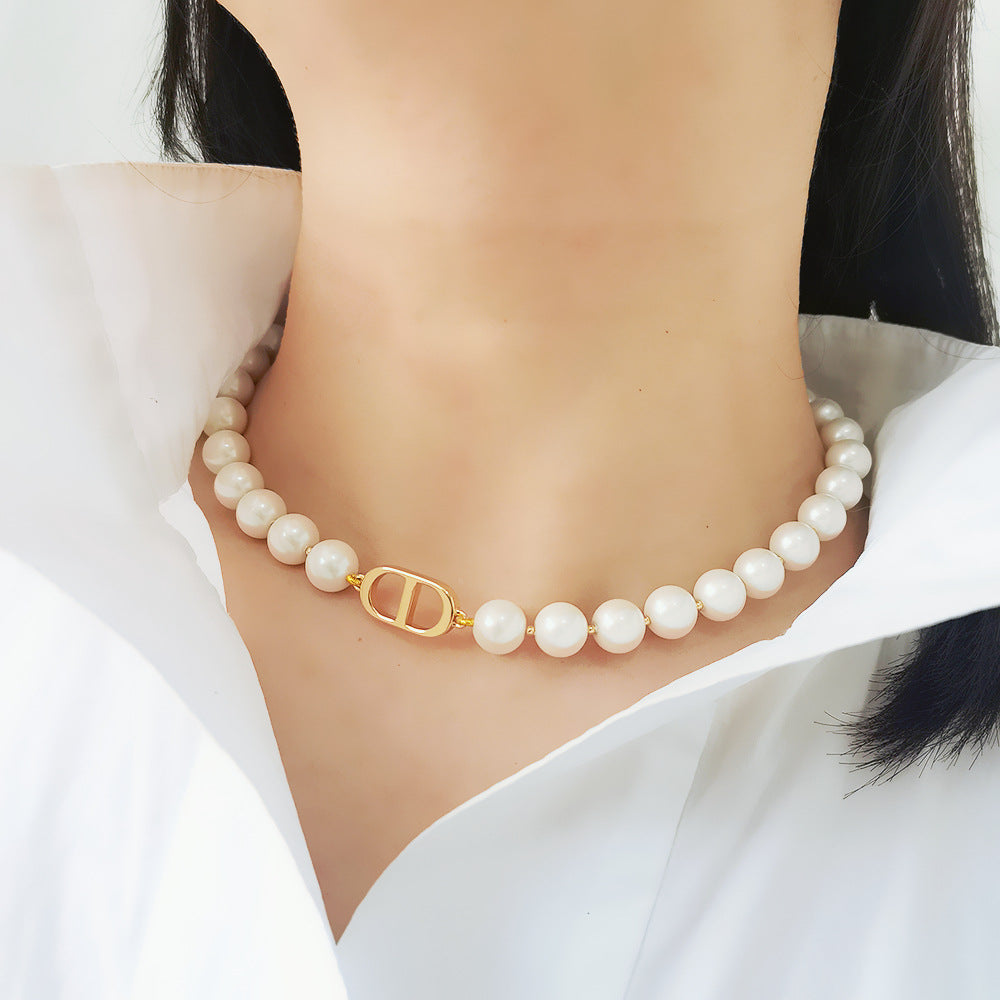 The image showcases a vintage-inspired pearl choker necklace with a gold-tone chain, featuring baroque-style details for a sophisticated and elegant look. This collarbone-length necklace is perfect for adding a touch of timeless charm to evening wear, special occasions, or everyday fashion statements.