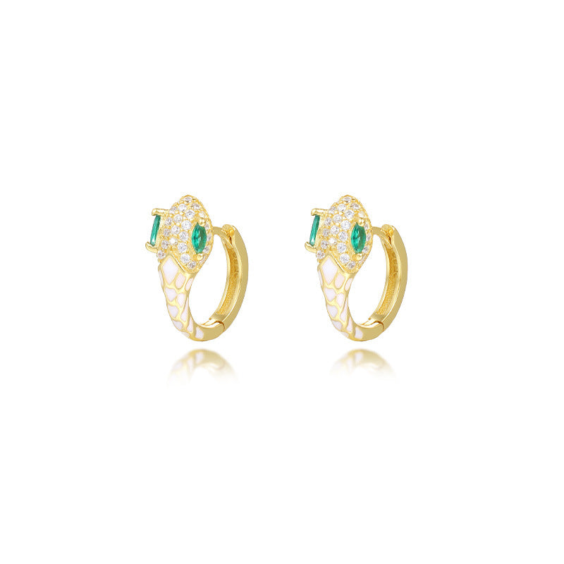A dynamic close-up of coiled serpent-inspired earrings crafted from S925 sterling silver, adorned with rainbow zirconia stones and glossy resin accents. The hoops elegantly wrap around the earlobe, styled with a monochrome outfit to highlight their eye-catching colors for both day and night occasions.