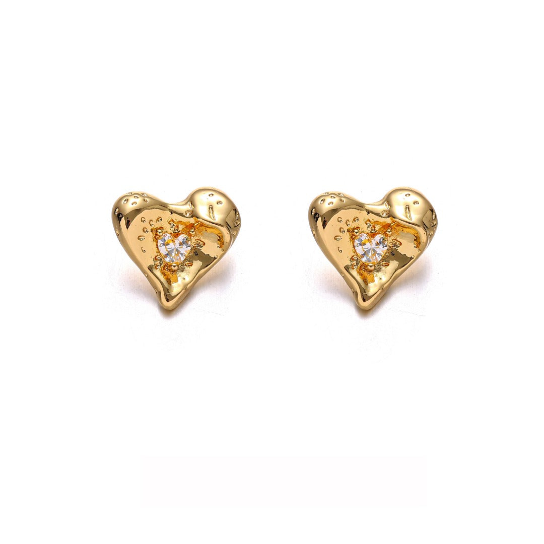 This image showcases a pair of shiny heart-shaped stud earrings with a polished gold-tone finish, designed to add elegance and charm. These minimalist yet eye-catching earrings are perfect for daily wear, date nights, and special occasions, making them a must-have for any fashion-forward jewelry collection. The delicate heart shape and radiant shine make them an ideal accessory for those who love chic and timeless designs.