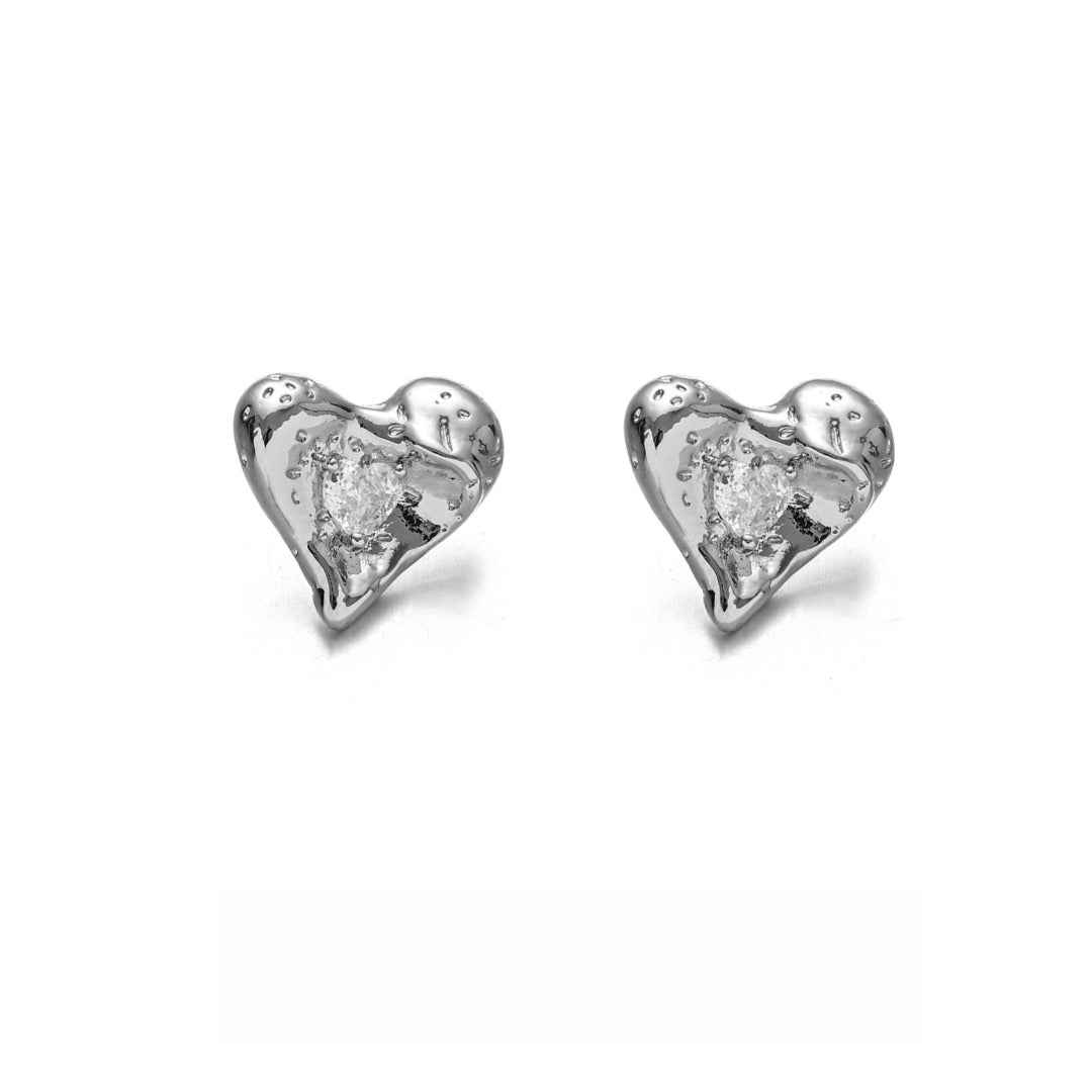 This image showcases a pair of shiny heart-shaped stud earrings with a polished gold-tone finish, designed to add elegance and charm. These minimalist yet eye-catching earrings are perfect for daily wear, date nights, and special occasions, making them a must-have for any fashion-forward jewelry collection. The delicate heart shape and radiant shine make them an ideal accessory for those who love chic and timeless designs.