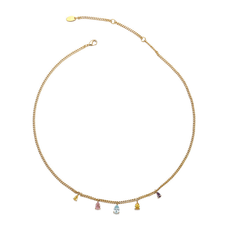 A radiant summer rainbow pendant necklace with vibrant, colorful charms hanging from a delicate gold chain, styled against sunlit skin at a beachside café, adding a playful and elegant touch to any vacation or casual outfit.