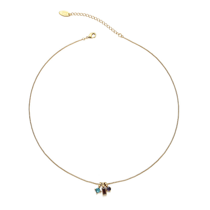 A radiant summer rainbow pendant necklace with vibrant, colorful charms hanging from a delicate gold chain, styled against sunlit skin at a beachside café, adding a playful and elegant touch to any vacation or casual outfit.
