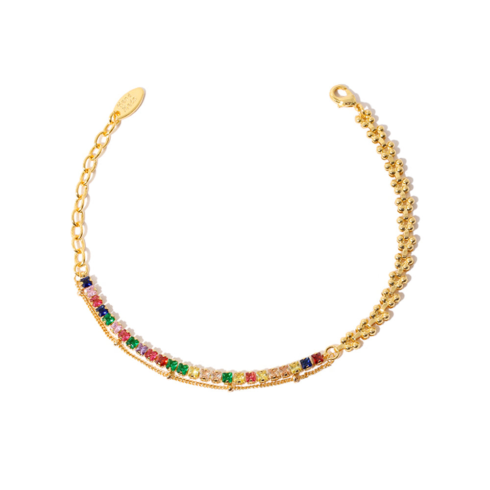 A hand adorned with a wheat chain bracelet combining 18K gold-plated brass links and prism-cut zirconia beads, styled alongside a ceramic coffee cup in a sunlit café setting. The hypoallergenic design maintains its luster against skin contact, while the textured wheat motif adds rustic elegance to both casual denim and linen outfits.