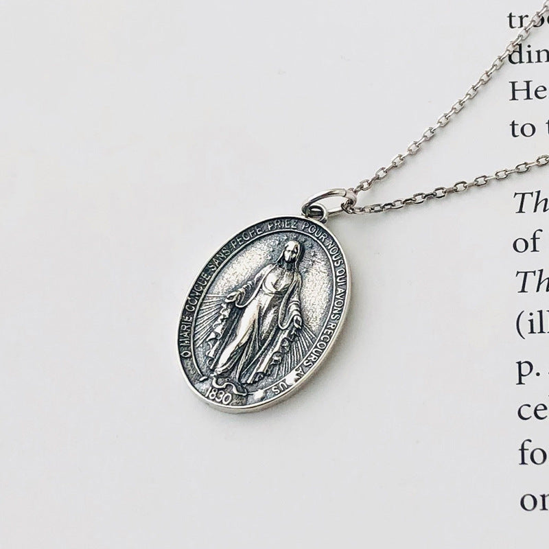A model wearing a vintage portrait pendant necklace crafted from S925 sterling silver, featuring intricate details in a polished silver tone. The antique-inspired design is styled with a casual outfit for daily wear or as a meaningful gift for art lovers.